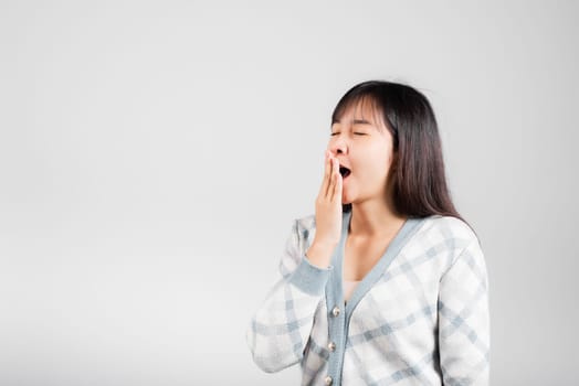 Sleepy woman closed eyes emotions tired and sleepy her yawning cover mouth open by hand, Portrait Asian beautiful young female sleep and energy studio shot isolated on white background with copy space
