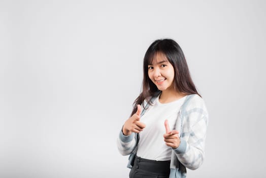 Woman excited smiling makes finger two gun gesture to camera isolated white background, Happy Asian portrait beautiful young female says you are chosen ll kill you or what up man with copy space