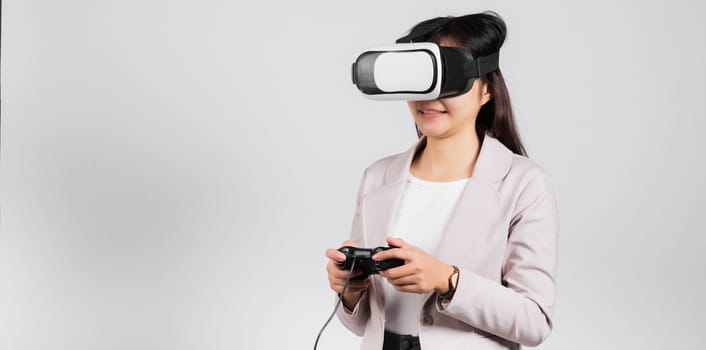 Smile woman confidence excited wear 3D VR headset device and playing game virtual reality experience with joystick isolated white background, Asian happy female play video game studio shot,copy space