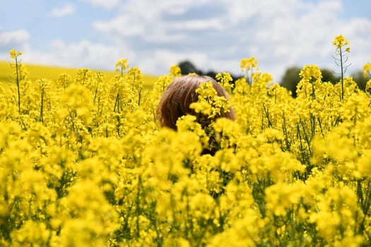 A woman is standing in a flowering field