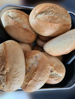 Crusty round bread rolls, known as Kaiser or Vienna rolls on linen towel, flat lay on rustic background with copy-space