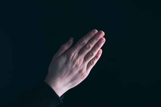 Praying hands with faith in religion and belief in God on dark background. Power of hope or love and devotion.