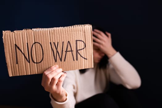 Sad woman calls to Stop war in Ukraine, raises banner with inscription No war.