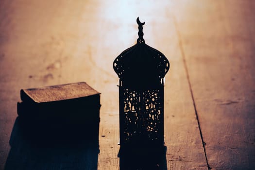Ramadan Kareem background. Ornamental Arabic lantern on vintage wooden background in the sunset