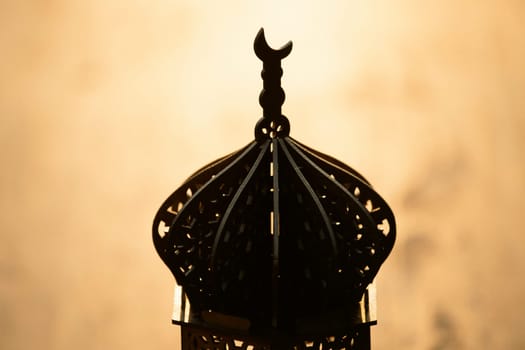 Ramadan Kareem background. Ornamental Arabic lantern on vintage wooden background in the sunset