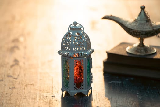 Ramadan Kareem background. Ornamental Arabic lantern glowing at night and the holy book of Quran.
