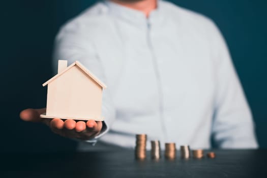 Real estate agent hand holdinga house model. Realtor, mortgage, your house, home loan concept. Copy space