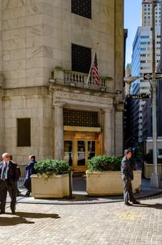 New York Stock Exchange golden colored Building Entrance with Security in suits standing in front, vertical