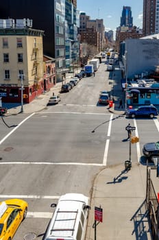 City Street crossroads with traffic, aerial view from The High Line, Chelsea, New York City during sunny winter day, vertical