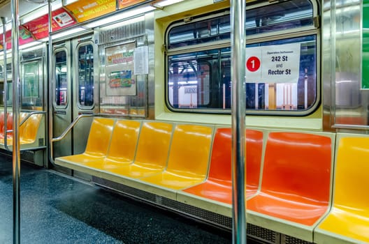 New York Subway with yellow and orange colored seats, no people, 242 St and Rector St Sign in the Window, horizontal