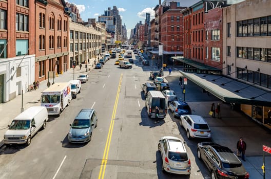 Chelsea city Street with lots of parked cars next to the street and traffic, New York City, aerial view from the High Line Rooftop Park, New York City during sunny winter day, horizontal