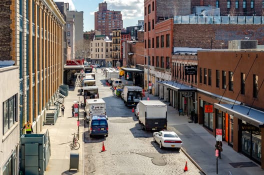 Chelsea City Street with lots of parked trucks on the street, aerial view, New York City during sunny winter day, horizontal
