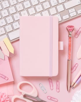 Hardcover notebook, Pink school accessories and keyboard on light pink, Top view, textbook mockup. Girly workplace with notebook, scissors, pencil, pen, paperclips, cards and watch. Back to school