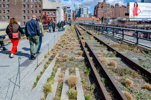 The High Line Rooftop Park, New York City with railroad track and People walking around during sunny winter day, Skyscraper around the park, horizontal