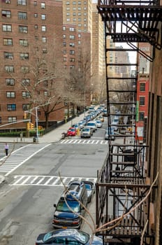 Chelsea City Street, New York City aerial view with emergency staircase and residential Building in front during sunny winter day, Residential Building facades in the background, vertical