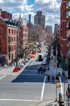 Chelsea City Street crossroads, aerial view from the High Line Rooftop Park, New York City during sunny winter day, lots of cars parked on the street vertical