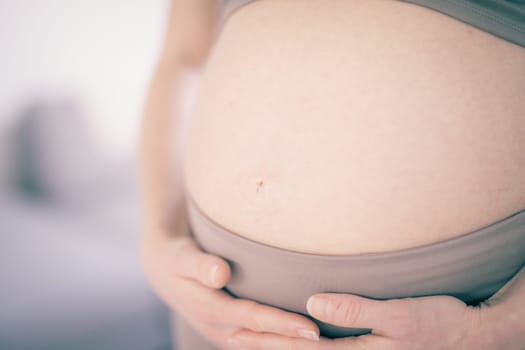 Pregnant woman belly. Pregnancy Concept. Pregnant tummy close up. Detail of pregnant woman relaxed at home
