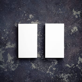 Two blank business cards on concrete background. Template for ID. Top view with copy space. Flat lay.