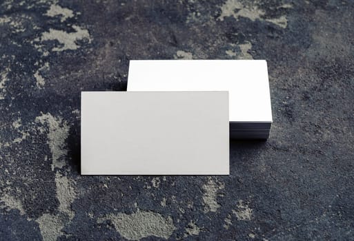 Photo of blank business cards on concrete background. For design presentations and portfolios. Mock-up for branding identity.