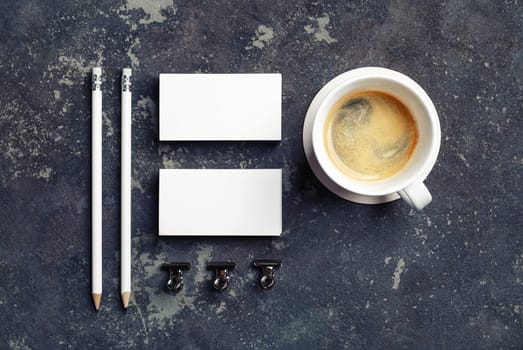 Coffee cup and blank stationery on concrete background. Objects for placing your design. Top view. Flat lay.