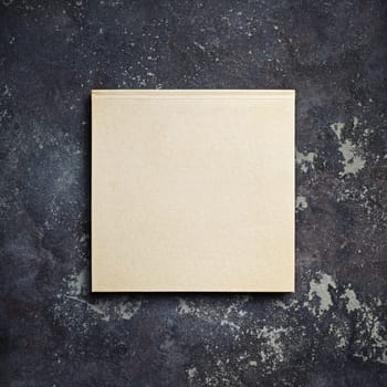 Photo of closed blank kraft brochure on concrete background. Template for placing your design. Top view with copy space. Flat lay.