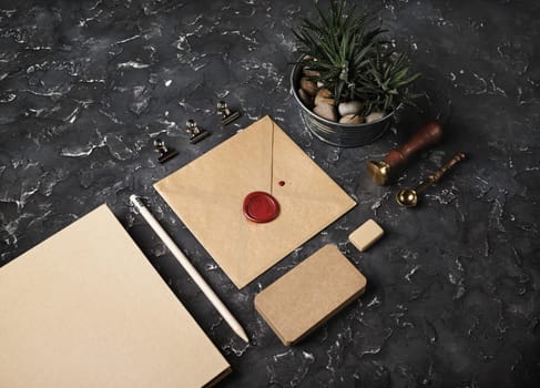 Brand identity mockup. Blank kraft stationery set on black plaster background.