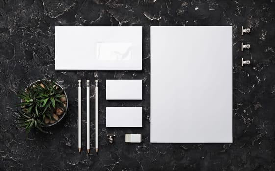 Photo of blank corporate identity. Stationery set on black plaster background. Branding mockup. Top view. Flat lay.