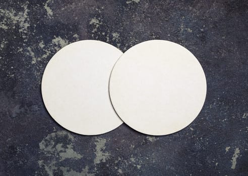 Photo of two blank beer coasters on concrete background. Top view. Flat lay.