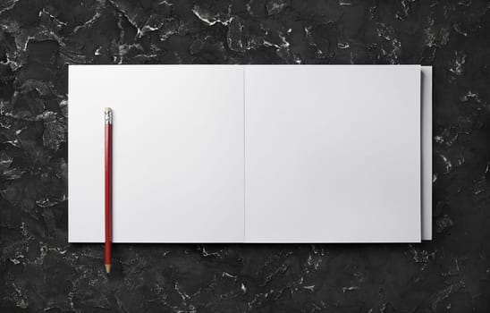 Photo of open sketchbook with blank pages and pencil on black plaster background. Top view with copy space. Flat lay.