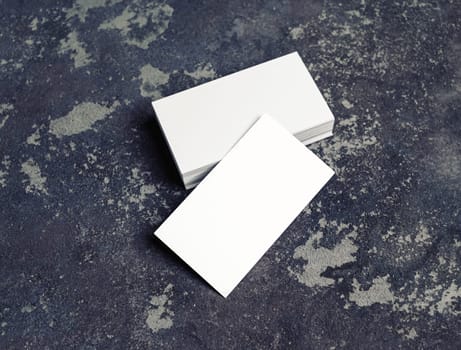 Blank white business cards on concrete background. Mockup for branding identity. Template for graphic designers portfolios.