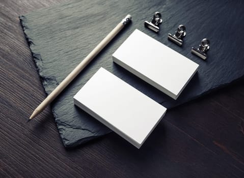 Photo of blank business cards, pencil and clips. Responsive design template.