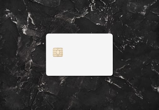 Blank white credit card on black plaster background. Bank card. Top view. Flat lay.