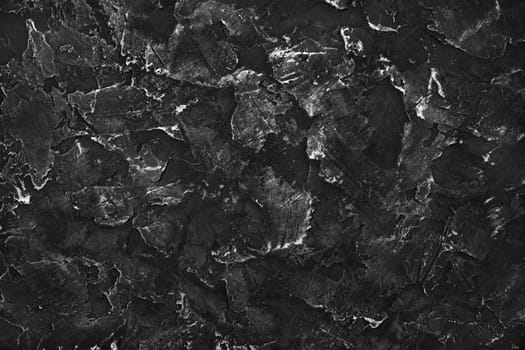 Black plaster background. Black stucco texture. Top view. Flat lay.