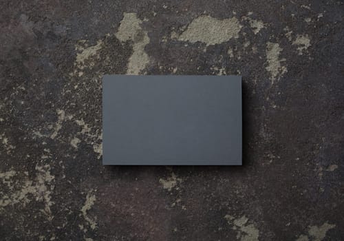 Photo of blank gray business card on concrete background. Mock-up for branding identity. Top view with copy space. Flat lay.
