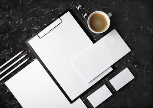 Photo of blank stationery set on black plaster background. Corporate identity mockup. Responsive design template. Top view. Flat lay.