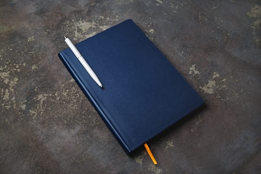 Blank notepad and pen on concrete background. Stationery elements. Template for placing your design.