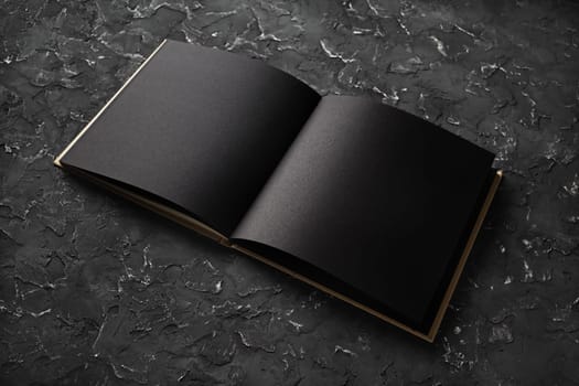 Photo. Open blank black brochure on black plaster background. Mock-up for graphic designers portfolios.