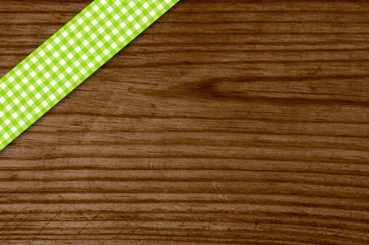 Old wooden table with green white checkered tablecloth