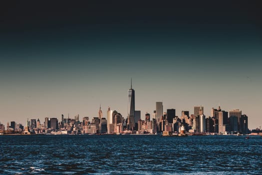 New York City Manhattan downtown skyline at dusk with skyscrapers illuminated over Hudson River panorama. Vertical composition.