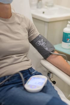 Doctor using sphygmomanometer with stethoscope checking blood pressure to a patient in the hospital