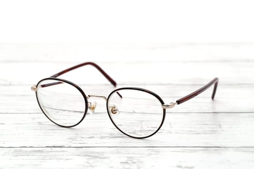 Stylish brown framed glasses on a white wooden table