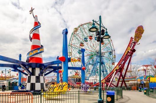 Different Rides and Ferris Wheel at Luna Park Amusement Park in Coney island, Brooklyn, Jewish National Day, New York City during winter day with cloudy sky, almost no People at the Park, horizontal