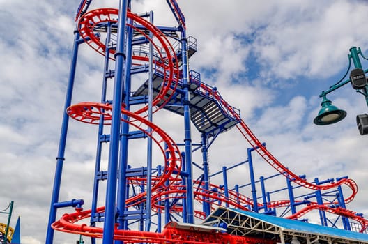 Soarin' Eagle Red Rollercoaster at Coney island, Brooklyn, New York City during winter day with cloudy sky, view from low angle, horizontal
