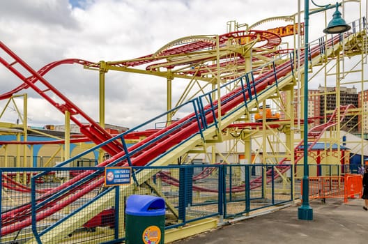 The Tickler Red Rollercoaster at Luna Park Amusement Park, view from the side, Coney island, Brooklyn, New York City during winter day with cloudy sky, horizontal