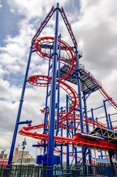 Soarin' Eagle Rollercoaster at Coney island, Brooklyn, New York City during winter day with cloudy sky, view from low angle, no people, vertical