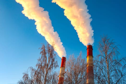 white smoke is coming out of the pipes in the blue sky. High quality photo