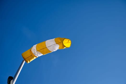 windsock on a bright blue sky at daytime, daylight, worms-eye view, video camera,