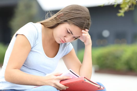 Concentrated student memorizing notes in the street