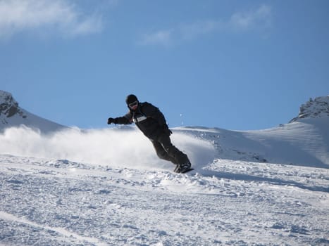 Snowboarder carving a turn on the piste