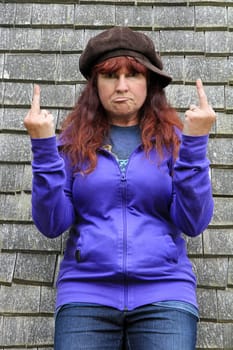 An elderly woman defiantly shows a stink finger. Despite the midlife crisis. Insulting with the middle finger